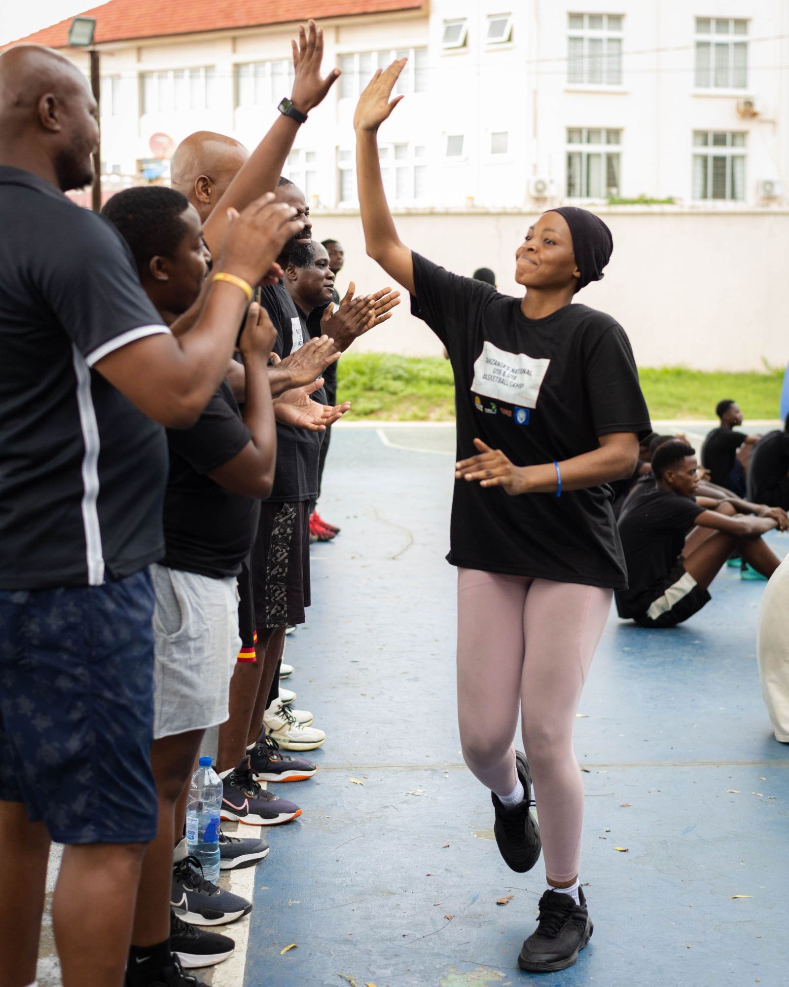 An athlete high-fiving coaches during a drill