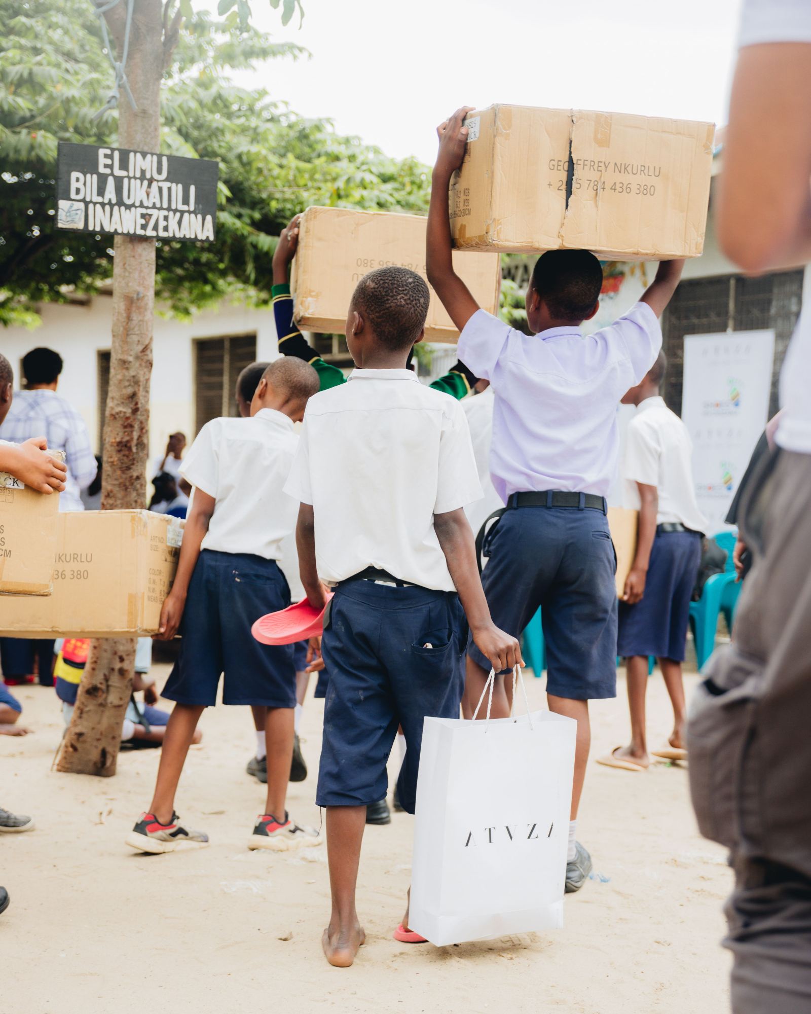 Students holding boxes of new shoes overhead