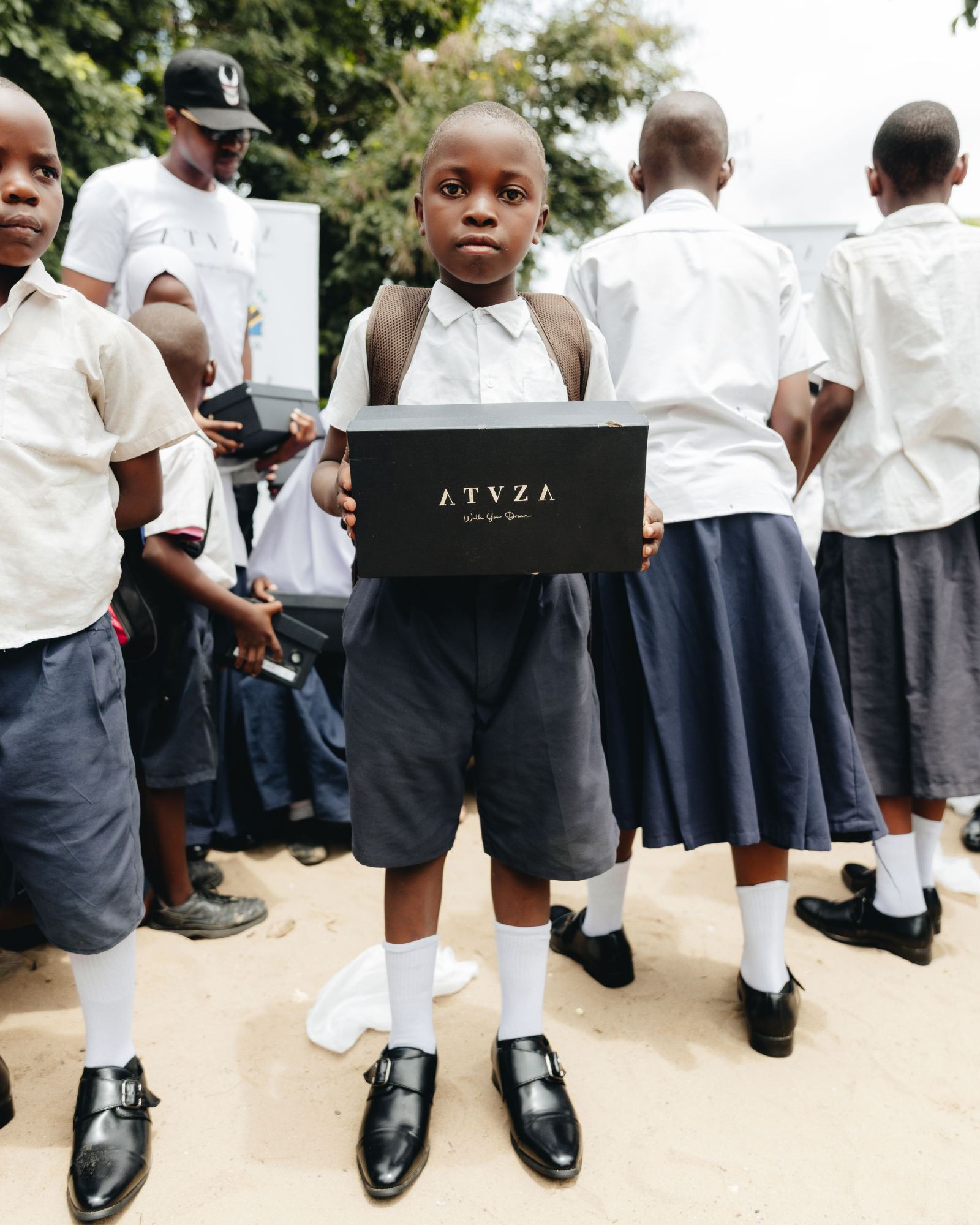 A student holding a box of new school shoes